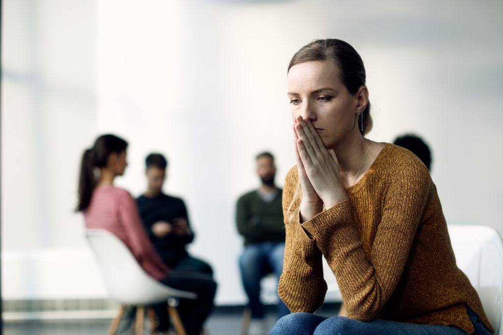 Woman experiencing Social Anxiety Disorder in a group setting.